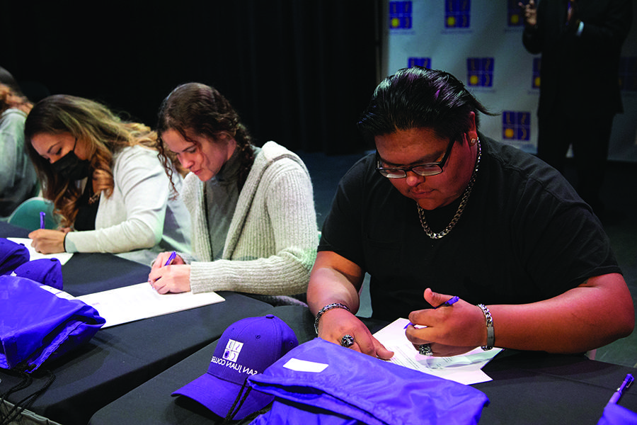 Three students signing at National Letter of Intent Signing Day 2022 Annual Report